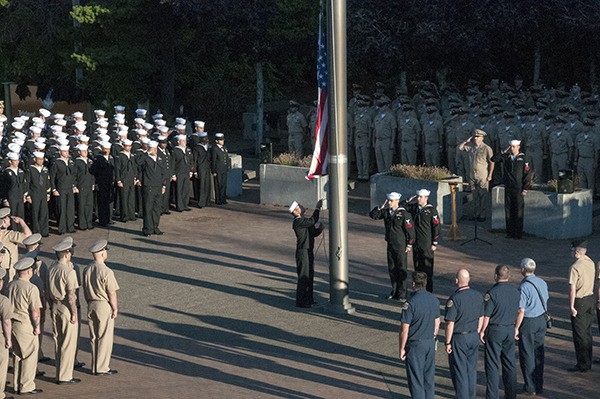 Sailors stand at attention as the national ensign is raised to half-mast during a 9/11 Remembrance Ceremony outside of the Trident Training Facility at Naval Base Kitsap - Bangor. The ceremony