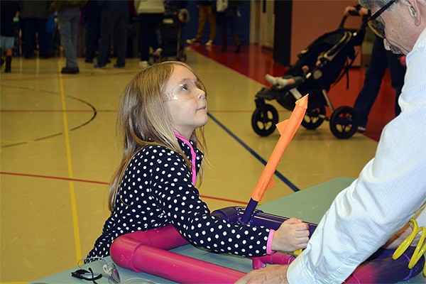 A student at Mullenix Ridge Engineering Night testing how high her rocket will launch at the Pneumatic Rockets table. This course encouraged STEM teachings.