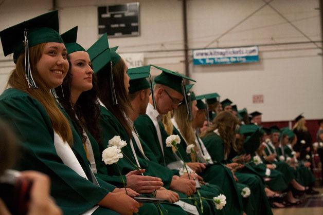 Klahowya students who have received their diplomas watch as their fellow seniors come down from the stage on Thursday.