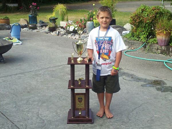 Poulsbo’s Jake Poggi stands with the trophy that he won during the 76th All-American Soap Box Derby Championships in Akron