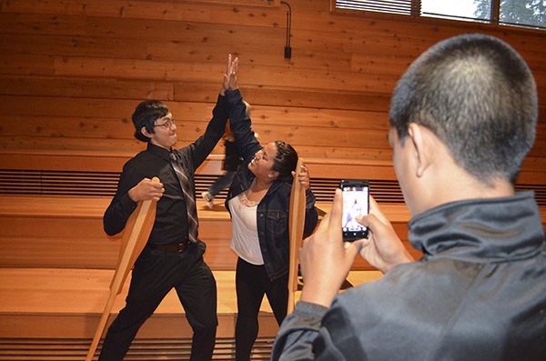 Graduates Vincent Chargualaf and Denita Santos strike a triumphant pose for a photo taken by Vincent’s brother