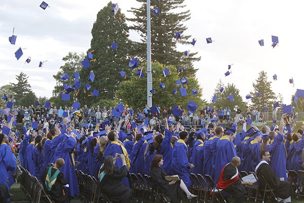 Bremerton High School graduates throw their caps in the air.