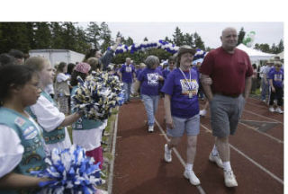 Girl Scouts from Troop 50599 wave pompoms during last year’s Survivor’s Lap as cancer survivors take to the Central Kitsap High School track.