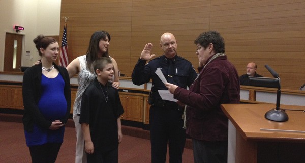 Newly-appointed Poulsbo Police Deputy Chief Robert Wright is sworn in by Mayor Becky Erickson during the Poulsbo City Council meeting Wednesday. Wright presented the police budget later in the evening.