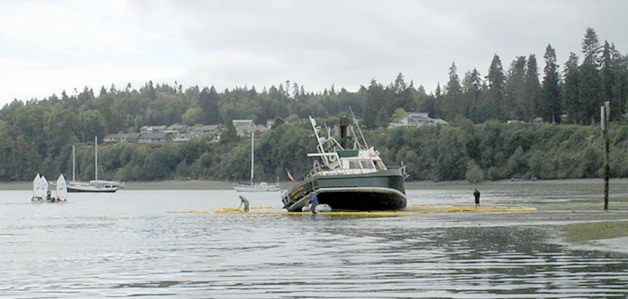 Crews deploy an spill containment boom around a 42-foot boat that ran aground outside the Port of Kingston on Tuesday morning.