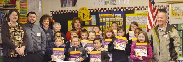 Third-grade students at Crosspoint Academy pose with the dictionaries they received recently from area Rotarians.