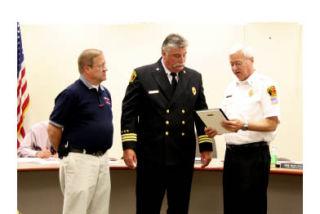 CKFR Chief Ken Burdette (right) presents Assistant Chief Roy Lusk with a plaque for 40 years of service to the department. CKFR Board of Fire Commissioners Chair Bob Muhleman looks on.