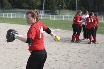 Olympic College’s Nikki Nesseth winds up for a pitch during practice before the second game of a doubleheader Tuesday. The team lost 7-1 in the first game to Everett Community College