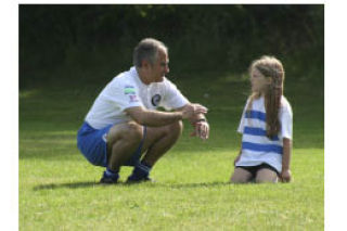 (Above) Kitsap Pumas Executive Director Ben Pecora talks soccer with a young camper Wednesday at Gordon Fields in Tracyton. (Right) Pumas forward Tony Kerr mixes soccer with fun at the Pumas youth camp.