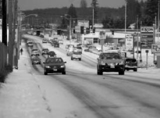 Cars travel up and down Wheaton Way Dec. 18 after snow accumulated throughout the area.  Snow continued to fall throughout last weekend weekend with some places seeing up to a foot and more. This railing in Central Kitsap collected about 8 inches.