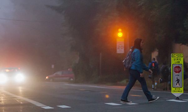 A student crosses Central Valley Road near one of the new 'knock-down' pedestrian signs outside Fairview Junior High School early Tuesday morning.