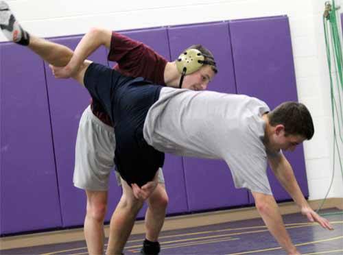 North Kitsap’s Jake Velarde practices a takedown on AJ Milyard Monday in the North Kitsap High School auxiliary gym.  Velarde and Milyard competed in the 2011 Mat Classic XXIII last season