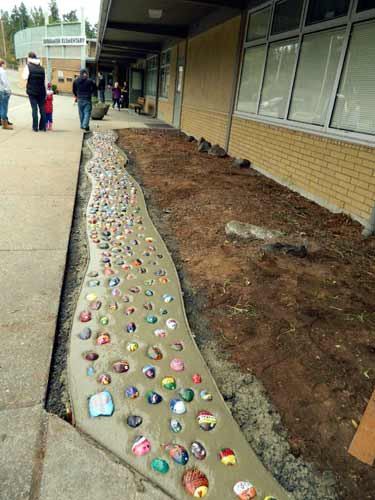 Stones were placed into a cement ‘stream’ in front of Suquamish Elementary School. The stones were   painted by the school community for a class project.