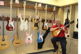 Dan DeMers opened American Guitars inside Kitsap Mall late last year. He sells a variety of guitars and now offers guitar lessons to customers.