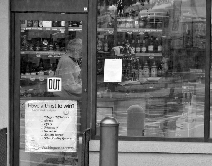 A customer buys alcohol at a state-run liquor store Wednesday morning in Bremerton.