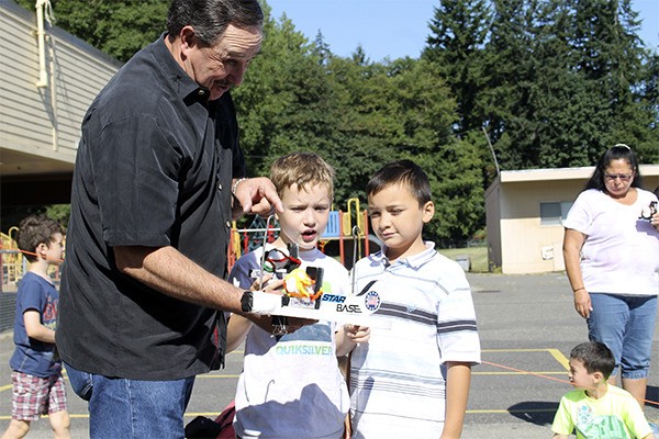 Starbase Atlantis Director Mo Yates looks over an egg harness with two Summer Science Academy students prior to the spacecraft’s descent and collision with the Cinder Block of Doom.