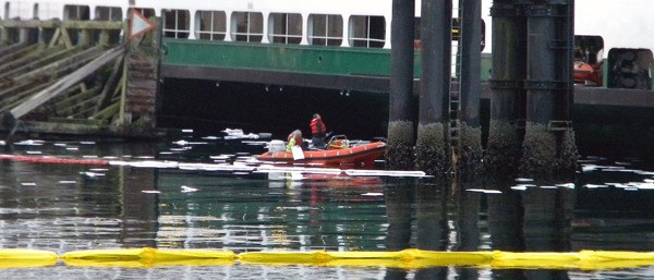 A containment boom and absorbent pads are used to contain and clean up a fuel spill at the Kingston ferry landing