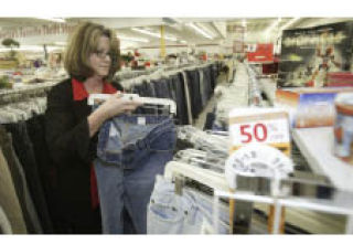 Value Village Manager Kathleen Palmer puts away a pair of jeans in the women’s section. The store