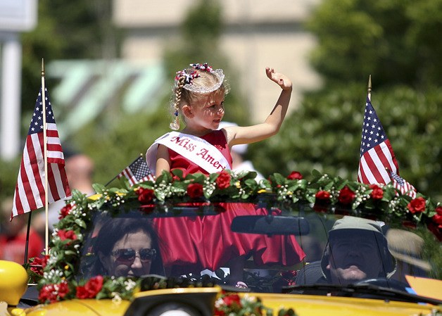 Little Miss Kingston Kendra Hawkins is escorted through the Kingston parade route Monday.