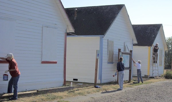 The Friends of Norwegian Point Park spruce up the historic cabins with a coat of paint.