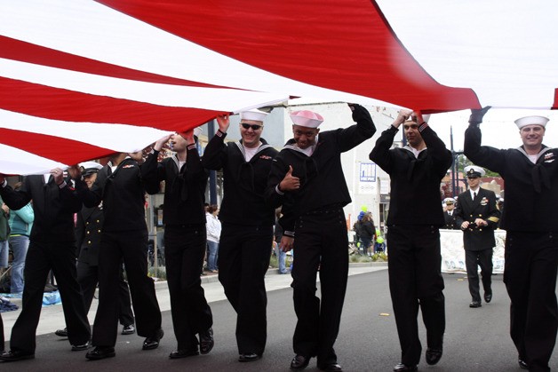 Sailors from the USS John C. Stennis carry a massive American flag during Saturday's Armed Forces Day Parade in downtown Bremerton.