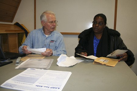 Bob Kieffer helps Angelia Myers prepare and file her income tax return Tuesday at the Silverdale Community Center. The AARP Tax-Aide program is a free service open to the public.