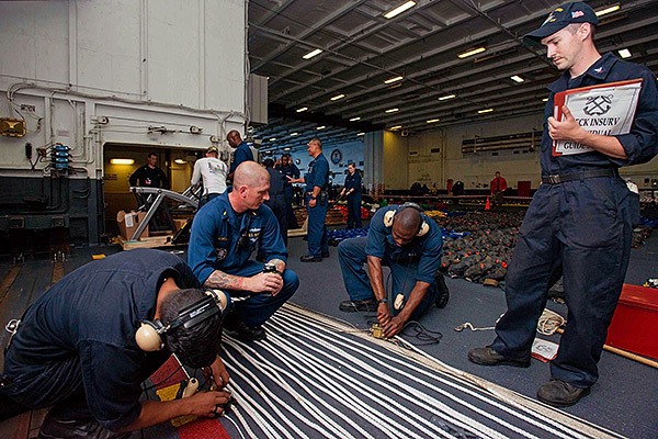 Sailors from USS John C. Stennis’ (CVN 74) Deck department 2nd division demonstrate proper use of a phone and distance line. The line is used during underway replenishments to show the distance between two ships. The crew is currently preparing for the Navy’s Board of Inspection and Survey