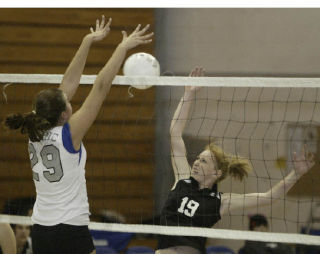 Lady Eagle Megan Shultz (19) stretches to block a spike during a game last year. A junior setter this season