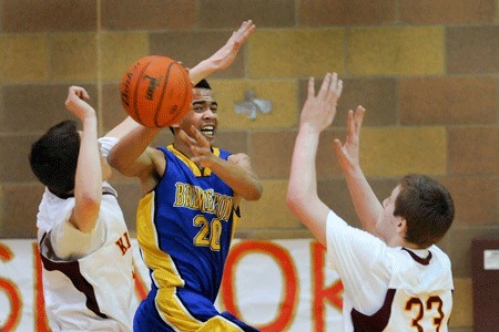 Bremerton High School junior Andre Coleman squeezes a pass between two defenders during the Knights’ 72-57 victory over Kingston High School at Kingston Tuesday.