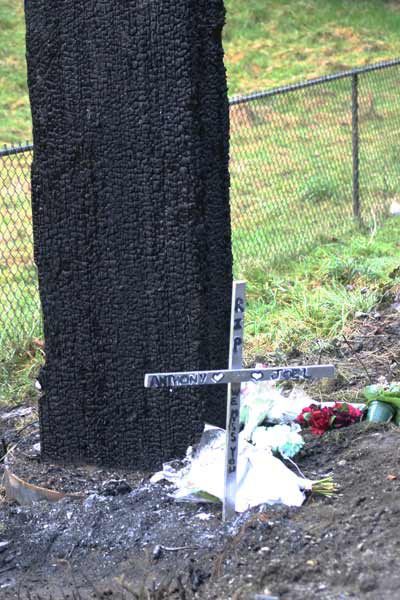 Remembrances mark the site of a fiery crash that killed two people Saturday morning.