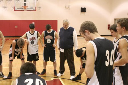 Crosspoint Academy boys basketball coach Dave Kerkhoff leads his players into prayer following practice Tuesday. The Bremerton private Christian school continues to run its athletic programs as the weakened economy takes its toll.