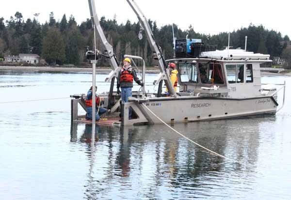 Biologists with Grette and Associates test soil in Appletree Cove Feb. 25 for the Port of Kingston.