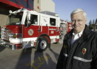 Central Kitsap Fire & Rescue (CKFR) Chief Ken Burdette stands in front of one of the 12 new fire engines the department received last week. The rigs were funded through a 2006 fire levy to replace CKFR’s aging fleet.