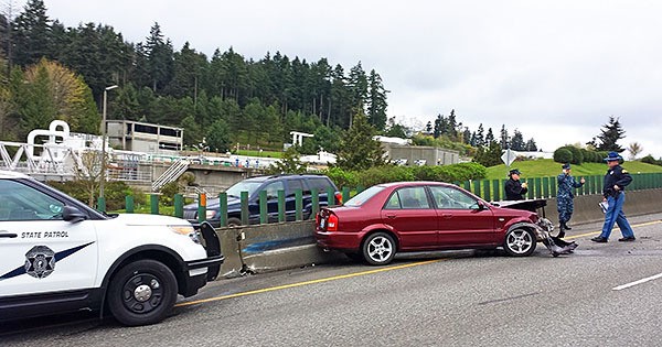 A Washington State Patrol Trooper investigates a crashed Mazda on State Route 3 on April 6.