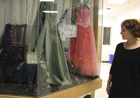 Catherine Kamp looks at the window display for the 'Oly Boutique' at Olympic High School. Kamp is one of the volunteers that helps gather dresses for girls to wear at school dances. Because dresses can be costly