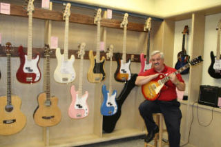 Dan DeMers opened American Guitars inside Kitsap Mall late last year. He sells a variety of guitars and now offers guitar lessons to customers.