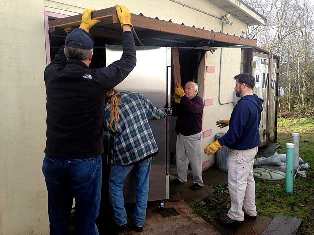 North Mason Rotary Club members move one of the two commercial freezers into the North Mason Food Bank. The freezers were donated as part of a joint project of five local Rotary clubs.