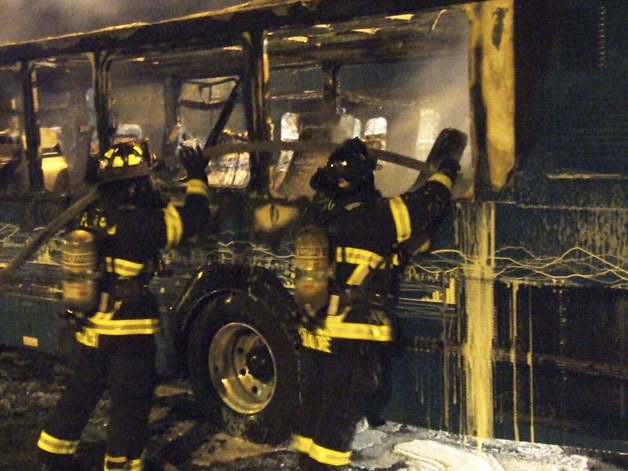 Poulsbo firefighters douse a smoldering Kitsap Transit bus Friday night in a Viking Way parking garage.