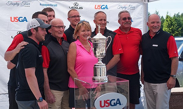 Workers at Gold Mountain Golf Club in Bremerton pose for a photograph with the U.S. Open Trophy at the club on June 6. The trophy was on display at the club 1-3 p.m. that day as part of the U.S. Golf Association’s trophy tour which displays the historic trophy at numerous locations across the county to kick off the 115th U.S. Open Championship which will be held June 18-21 at Chambers Bay in University Place.  The trophy lists winners from 1895-2014 and has room for possibly 29 more names. The original trophy was destroyed by fire in 1946 and the replacement was created in 1947. From left is Chris Keough