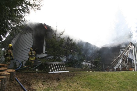 Firefighters battle a house fire Thursday in the 9000 block of Holly Road.