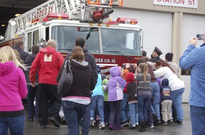 Children and others in the community help give Ladder 51 a big push into Station 51 on Silverdale Way Saturday. The 105-foot ladder engine is the newest addition to Central Kitsap Fire and Rescue's fleet.