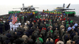 Sailors put their hands over their hearts as the color guard parades the colors during a memorial service for Aviation Boatswain’s Mate (Equipment) 3rd Class Gatlin Green on the flight deck aboard the Nimitz-class aircraft carrier USS John C. Stennis (CVN 74) April 28. The Stennis is on a scheduled six-month deployment to the western Pacific Ocean.