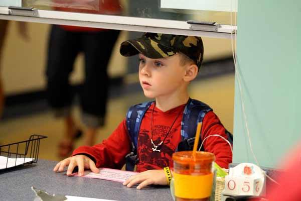 Poulsbo Elementary is currently one of two schools in the North Kitsap School District facing higher enrollment than projected.  Pictured is a student at Poulsbo waiting at the front office during the first day of school Sept. 5.