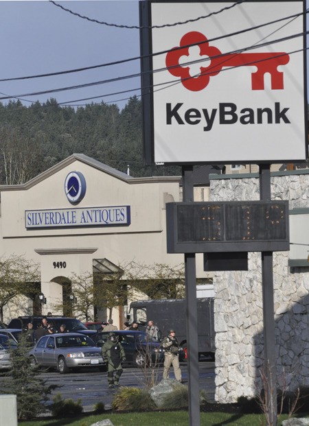 A bomb technician heads into the Silverdale Way branch of Key Bank March 15 during a massive response to a robber in search of $50