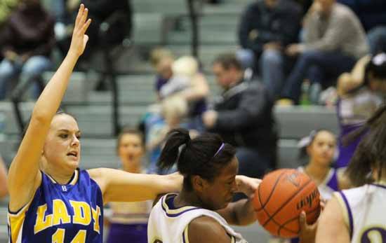 Bremerton's Sawyer Kluge blocks a two-point attempt by North Kitsap's Indigo Williams Jan. 10 during a league game in the North Kitsap High School Gymnasium.