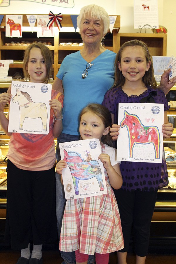 Sluys Bakery owner Loretta Sluys presents gift cards to the winners of the bakery's coloring contest. From left