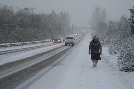 Wesley Woolridge walks along Silverdale Way Monday afternoon. The 18-year-old Olympic College student