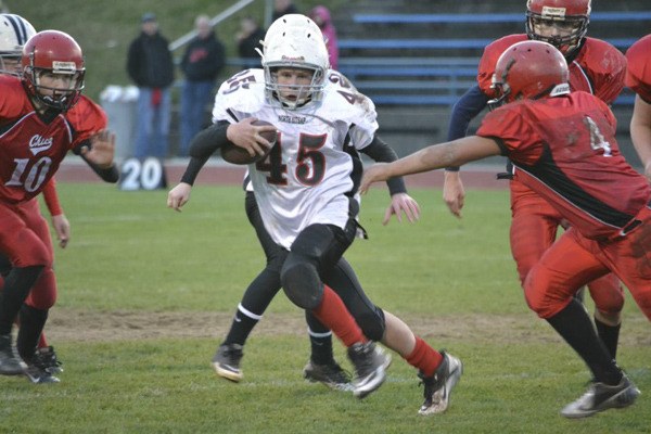 A-string NK Warriors player Danny Fehlman breaks a tackle as he rushes downfield in the second quarter of the Kitsap County Pee-Wee football championships against Chico Nov. 10 at the Bremerton High School football field.