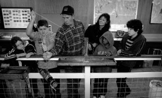 Lab director Ralph St. Andre works with students performing a salinity test at the Poulsbo Marine Science Center. Suquamish students were visiting and running the gamut of experiments in the new floating lab facility.  Pictured are (L-R) students Trenna McDaniel