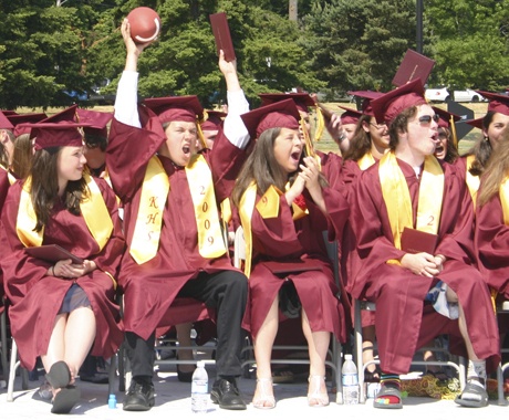 Justin Symes raises a football along with his diploma Saturday as the Kingston High School class of 2009 celebrates its graduation.